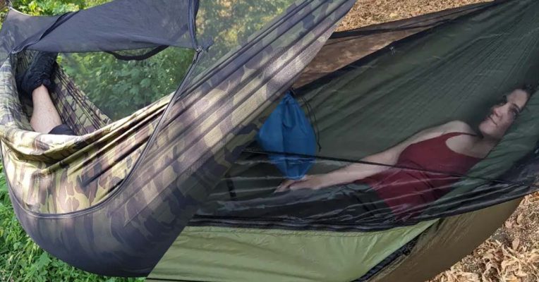 a woman sleeps in the hammock with net